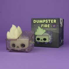 a plastic box with a fake skull inside and a dumpster fire toy in front