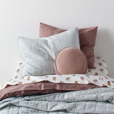 a bed topped with lots of pillows and blankets