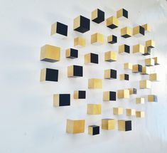 a white wall with gold and black squares on it