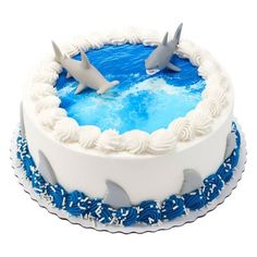 a blue and white cake with two sharks on top