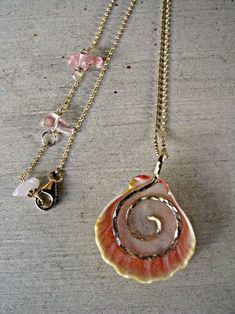 two necklaces that have shells on them, one is pink and the other is gold