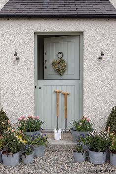 a house with potted plants in front of it and a wreath on the door