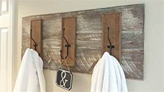 two towels hanging from hooks on a wall