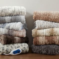 a pile of towels sitting next to each other on top of a wooden floor with an electric hair dryer