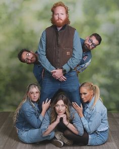 a group of people posing in front of a photo with their hands on the hips