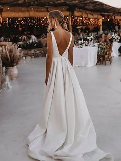 a woman in a white wedding dress looking down at the ground