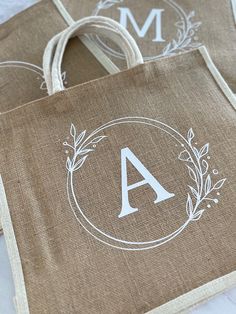 two burlap bags with monogrammed designs on them, one has the letter a in it