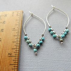 Each pair is handcrafted with sterling silver and features beautiful turquoise stones, measuring 2 inches long. Add a pop of color to your look with these unique and eye-catching earrings. Turquoise Teardrop Hoop Earrings Nickel Free, Teardrop Turquoise Nickel-free Hoop Earrings, Nickel-free Teardrop Turquoise Hoop Earrings, Nickel-free Turquoise Teardrop Hoop Earrings, Turquoise Teardrop Nickel-free Hoop Earrings, Turquoise Sterling Silver Hoop Earrings For Pierced Ears, Handmade Turquoise Sterling Silver Hoop Earrings, Turquoise Sterling Silver Nickel-free Hoop Earrings, Turquoise Teardrop Sterling Silver Hoop Earrings