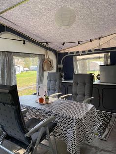 the inside of a camper with two chairs and a table in front of it