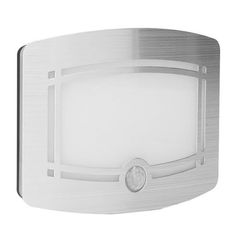 an image of a bathroom light that is on the white wall and has metal trim around it