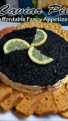 a black and white cake with lemon slices on it surrounded by crackers, chips