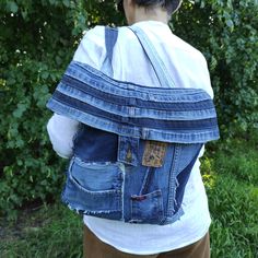 a person wearing a denim backpack with holes in the back