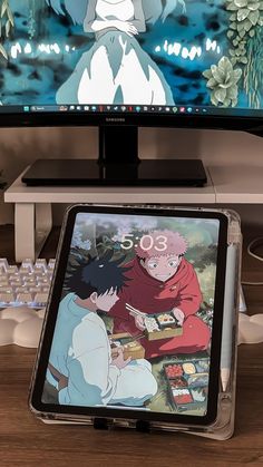 an anime scene is displayed on the computer screen and in front of it's keyboard