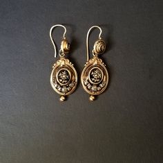 I purchased these beautiful Memento Mori, Mourning Earrings years ago, and have never worn them.  When I purchased them, I was told that the raised center, which is able to be removed by a jeweler, would contained a lock of a loved one's hair.  I have never investigated this.  They are gold with a seed pearl in the center.  There's a draped ribbon of silver below.  A gold bead hangs from the bottom. The background and trim is black enameled.    I don't feel comfortable wearing dangling earrings, so I reluctantly decided to sell them.  I hope they go to someone who will appreciate the design and the workmanship. Antique 14k Gold Hallmarked Earrings, Vintage Drop Earrings For Ceremonial Occasion, Vintage Ceremonial Drop Earrings, Victorian Hallmarked 14k Gold Earrings, Antique Yellow Gold Ceremonial Earrings, Antique Ceremonial Earrings For Pierced Ears, Victorian Hallmarked Earrings For Ceremonial Occasions, Antique Yellow Gold Drop Earrings, Vintage Engraved Earrings For Wedding