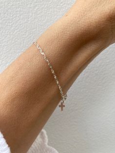 This super sparkly bracelet looks great stacked with other dainty bracelets! D E T A I L S  *925 sterling silver sequin chain measuring 1.8mm wide *A tiny sterling silver cross hangs from the end. *Hallmarked spring ring clasp.  S I Z I N G *  H E L P Choose the length from the drop down menu. Use the length guide as a reference. C A R E * T I P This is a dainty bracelet so please treat it with care. To maintain it in great condition avoid contact with water, perfume and harsh chemicals.Also remove when exercising, sleeping and doing housework in case it snags. Sterling silver can tarnish over time especially in humid conditions so always store in a dry place and if necessary clean with a jewellery cloth. P A C K A G I N G All our products are gift ready. T E R M S* O F* S A L E S & F A Q Minimalist Sterling Silver Cross Bracelet, Dainty Sterling Silver Cross Bracelet, Nickel Free Silver Cross Bracelets, Nickel Free Sterling Silver Cross Bracelets, Silver Bracelet With Cross Pendant As Gift, Nickel-free Silver Cross Bracelets, Silver Nickel-free Cross Bracelet, Dainty White Gold Bracelet With Silver Chain, Dainty Sterling Silver Bracelet With Silver Chain