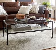 a living room with a couch, coffee table and other items on the floor in front of it