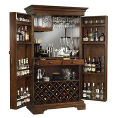 a wooden bar with wine glasses and liquor bottles on the shelves in front of it