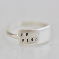 The Cherished inspiRING makes for the perfect everyday ring that features your favorite little reminder.Designed to be the little sister to the wide inspiRING, this ring will be one you cherish for years to come. Letters are individually stamped by hand, making each ring one of a kind. The message is left justified in our signature teeny-tiny upper case block font. Choose one of our messages or create your own https://www.etsy.com/listing/896794788 .details+ message plate measures 5/8" wide x 1/ Everyday Meaningful Hand Stamped Stackable Rings, Inspirational Adjustable Sterling Silver Rings, Adjustable Inspirational Sterling Silver Rings, Minimalist Hand Stamped Rings For Everyday, Modern Personalized Stackable Rings For Everyday, Modern Personalized Everyday Stackable Rings, Minimalist Everyday Hand Stamped Rings, Adjustable Inspirational Rings For Everyday, Everyday Minimalist Hand Stamped Rings