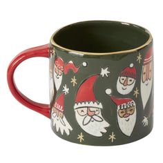 a green and red coffee mug with santas on it