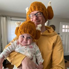 a man holding a baby wearing a knitted hat