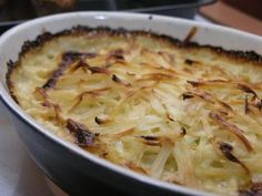 a casserole dish with onions and cheese in it sitting on a counter top