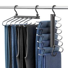 several folded jeans hanging on a metal rod