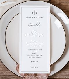 a table setting with white plates and silverware on it, including a menu card