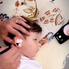 a woman is combing a small child's hair