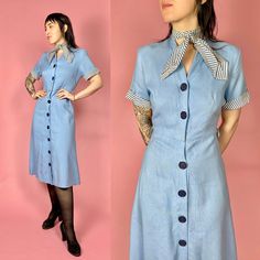 Such a cute 1940s Blue Day Dress made from loosely woven cotton with a Striped Cuffs and Tie at the Neckline and Buttons down the front! -----✂------Measurements--------✂------ All measurements are taken with the garment lying flat. Fits size Small to Medium but please double check with the measurements below. Shoulder to Shoulder: 15" Pit to Pit: 19" Across Waist: 13.5" Hips: 20.5" flat max Total Length: 45.5" Shoulder Seam to Cuff: 8.5" Model is 5'6" and her measurements are: (Bust: 34.5") (Wa Blue Vintage Dress With Buttons For Vintage Fashion, Spring Blue Cotton Vintage Dress, Blue Vintage Dress With Buttons For Spring, Spring Blue Vintage Cotton Dress, Spring Blue Vintage Dress With Buttons, Blue Vintage Dress With Buttons, Vintage Light Blue Cotton Dress, Light Blue Vintage Cotton Dress, Blue Cotton Knee-length Vintage Dress