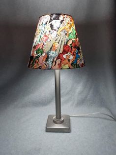 a lamp that is sitting on top of a white surface with cartoon characters all over it