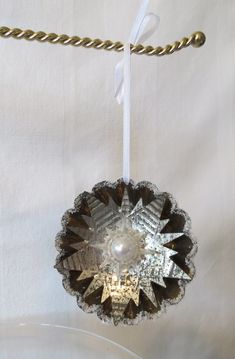 an ornament hanging from a chain on a white cloth covered tablecloth,