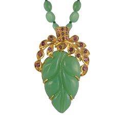 Using the ancient art of stone carving, this striking one-of-a-kind chrysoprase pendant has been hand-engraved and hand-carved into a leaf pattern. The pendant which is made of sterling silver coated with 24ct gold vermeil is embedded with pink tourmalines at the top. It comes with a 28 inch chrysoprase chain.  It has matching earrings. Sterling silver with 24ct gold plate. Embedded with crysoprase and pink tourmalines.  Store your jewellery in a soft lined pouch or box separately so they don't damage each other.  Precious metals naturally tarnish with exposure to air as well as perfumes, moisturiser, makeup, hairspray, perspiration, household cleaning products, chlorine and salt. Please avoid exposing your jewellery to these conditions and always remove it before swimming, showering, exer Tourmaline Pendant, Artisan Gift, Silver Coat, Jewelry Ring Box, Gifts For New Mums, Pearl Jewellery Earrings, Evil Eye Jewelry, Eye Jewelry, Stone Carving