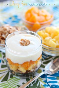 there are many desserts on the table with spoons and bowls around them, including fruit