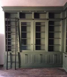 an empty room with green bookcases and shelves