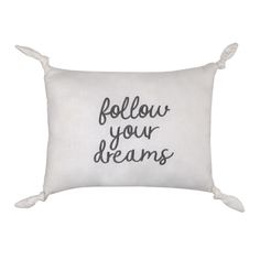 a white pillow with the words follow your dreams printed on it and tasselled edges