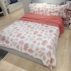 a bed with red and white bedspread in a bedroom next to a dresser