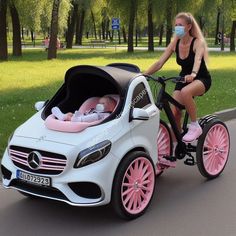 a woman wearing a face mask is riding a toy car with a baby in it