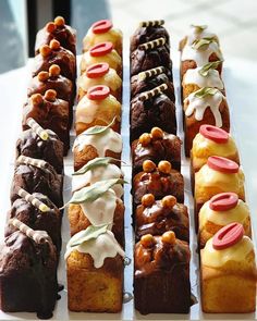 there are many different types of pastries on the trays that are lined up