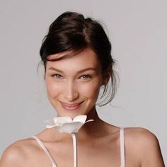 a woman with a flower in her mouth posing for the camera while wearing a bra