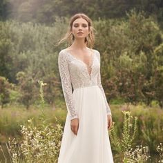 a woman in a white wedding dress standing outside