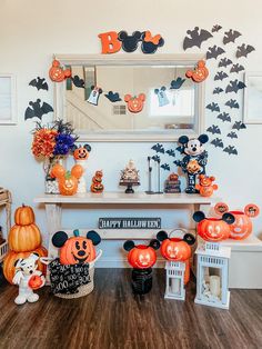 a room decorated for halloween with pumpkins and decorations on the wall, mickey mouse heads