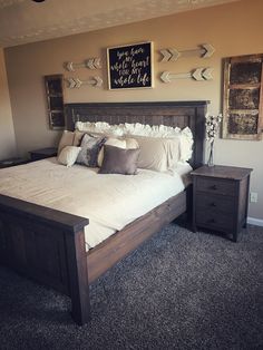 a bedroom with a bed, nightstands and pictures on the wall above it's headboard