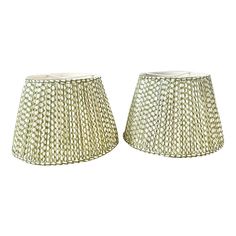 two white lampshades sitting next to each other on a white background, one has a light green shade