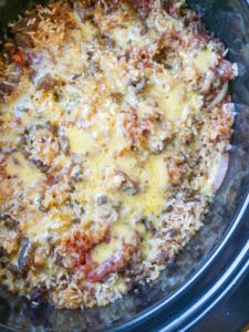 a crock pot filled with meat and cheese