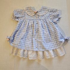 Vintage blue gingham and ruffle, toddler dress. Tagged 18 months Measures 16" shoulder to bottom hem Short Sleeve Checkered Plaid Dress With Ruffles, Cotton Gingham Plaid Dress With Ruffles, Gingham Plaid Cotton Dress With Ruffles, Blue Plaid Ruffle Dress For Spring, Blue Plaid Dress With Ruffles For Spring, Cute Ruffled Plaid Dress For Spring, Cute Gingham Dresses With Lace Trim, Spring Plaid Dress With Lace Trim, Picnic Gingham Dress With Lace Trim