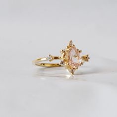 This ring is an elegant beauty for the ages. A peachy morganite set 14K solid gold. Definitely a timeless classic. Available in yellow gold vermeil, rose gold, and silver. Material: - 14K solid gold - Natural Morganite 7x5mm - Round CZs **This item is made to order, please allow 1-2 weeks for your order to be shipped. Shipping: Domestic: Ship via USPS priority mail International: $15 for international standard shipping. $10 to Canada. Online Return Policy: Due to the made to order nature, this r Classic Morganite Diamond Ring In Yellow Gold, Heirloom Morganite Jewelry In Yellow Gold, Gold Morganite Diamond Ring With Center Stone, Classic Gold Morganite Jewelry, Classic Morganite Gold Jewelry, Heirloom Gold Ring With Morganite, Gold Morganite Diamond Ring With Prong Setting, Elegant Teardrop Morganite Rings, Morganite Fine Jewelry In Yellow Gold