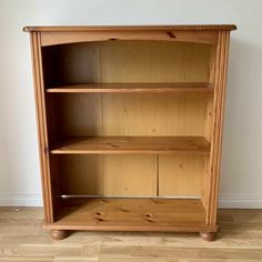 a wooden bookcase sitting on top of a hard wood floor