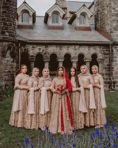 a group of women standing next to each other in front of a building