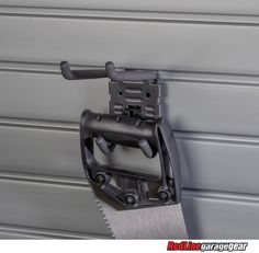 a saw is attached to the side of a garage door by a metal holder with two handles