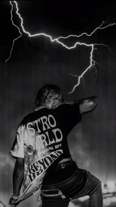 a man standing on top of a skateboard under a lightning filled sky